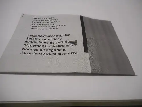 Montageanleitung mit Sicherheitshinweisen für ein Produkt der Marke Remeha, neben einer kleinen Schraube auf hellem Hintergrund.